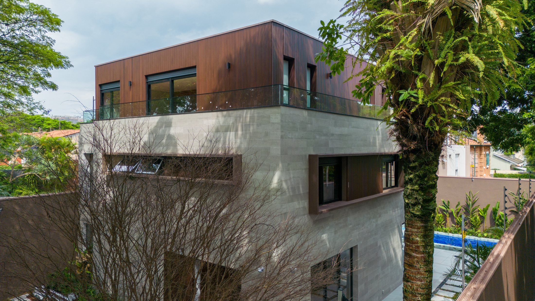 Fachada contemporânea da Casa Schutz com volumes em madeira e concreto.